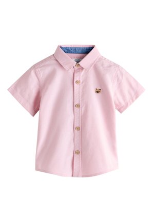 Ružová krátkym rukávom košeľa na gombíky, s modrým lemovaním goliera a malou vyšitou tvárou medveďa na ľavom hrudníku.