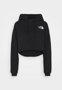 Černá crop mikina s kapucí z měkké látky, s kapucí na šňůrku a bílým logem na levé straně hrudi. Dlouhé rukávy s žebrovanými manžetami.