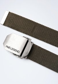 Ceinture tissée vert olive avec une boucle en métal argenté portant le texte "PME LEGEND". La boucle est angulaire et texturée.