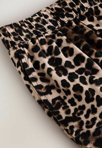 Kumarain graffiti kankaan mustriga, mustade ja pruunide laikudega. Elastne vöökoht, millel on kogutud disain. Pehme tekstuur ja sile viimistlus.