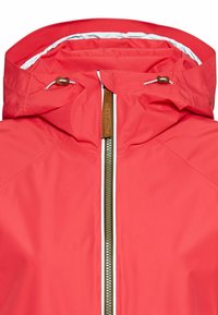 Red waterproof jacket with a high collar, contrasting white lining, front zipper, and adjustable drawstrings on the hood.