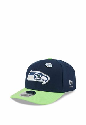 Navy blue and lime green Seattle Seahawks cap featuring team logo front, NFL Draft pin on top, and New Era logo on the side.