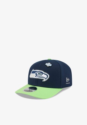 Navy blue and lime green Seattle Seahawks cap featuring team logo front, NFL Draft pin on top, and New Era logo on the side.