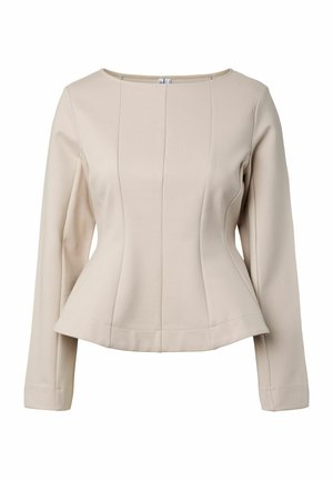 Bézs hosszú ujjú női blúz kerek nyakkivágással és testhezálló, enyhén bővülő derékrésszel, egyszínű háttér előtt.