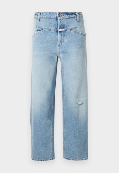 Jean en denim bleu clair avec une coupe décontractée, présentant une petite déchirure usée, cinq poches et une fermeture par bouton à la taille.