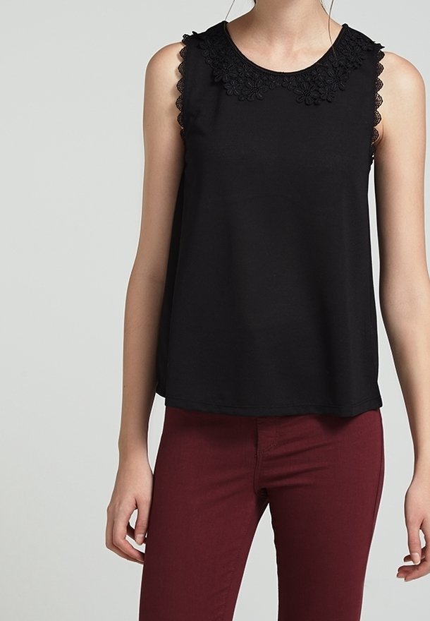 Černý bezramínkový top s květinovou krajkovou výstřihem, vyrobený z měkké tkaniny, v kombinaci s burgundskými upnutými kalhotami. Elegantní a jednoduchý design.