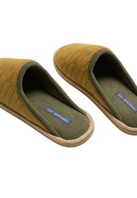 Zapatillas acolchadas de color mostaza con forro acanalado en verde oliva y plantilla texturizada. Suela de goma natural y detalles en etiqueta azul visibles.