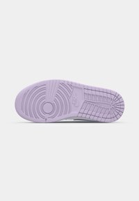 Semelle d'une basket Nike lavande avec des motifs de bande de roulement circulaires et en grille, montrant le logo Nike au centre.