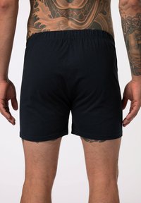 Boxer shorts neri in cotone con una fascia elastica, aderiscono perfettamente al corpo, caratterizzati da una texture liscia e un design minimale.