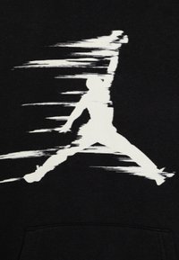 Felpa nera con cappuccio caratterizzata da una silhouette bianca sfocata di una figura che salta, mettendo in evidenza il movimento, con una tasca a canguro sul fondo.