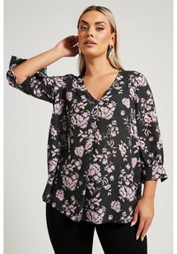 Svart blommig blus med rosa blommönster, V-ringning och trekvartslånga ärmar med manschettdetalj. Mjuk och smidig tyg.