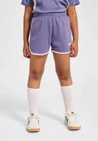 Lila sportshorts med rosa detaljer och en bekväm elastisk midja, kombinerade med knähöga vita strumpor och vita sneakers.