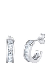 Øreringe af sterlingsølv i form af hoops, prydet med en kanal af rektangulære klare sten foran. Poleret overflade med sikker post-back lukning.