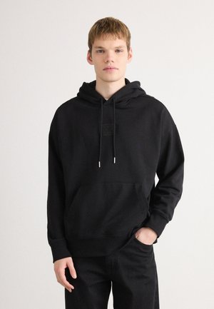 Zwarte hoodie van katoenmix, met een voorzak, trekkoorden met metalen uiteinden en een gestructureerde patch op de borst.