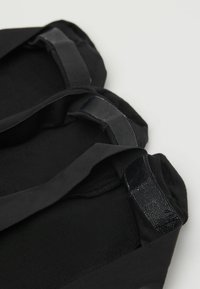 Bolsa de tela negra con textura suave, que cuenta con dos asas robustas. El diseño es sencillo, sin logotipos ni patrones visibles.