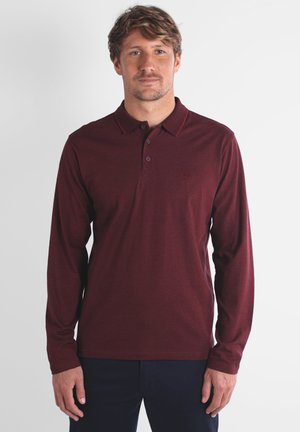 Polo à manches longues bordeaux avec une patte de boutonnage à deux boutons et un col contrasté. Texture subtile et petit logo brodé sur la poitrine.