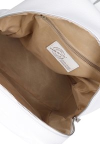 Witte leren handtas interieur met een gladde, tan kleurige voering en een ritsvak. Etiket zegt "Made in Italy." Rits hardware inbegrepen.