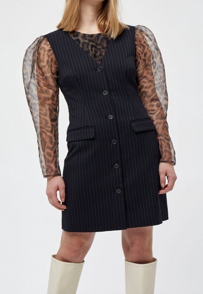 Schwarzes Nadelstreifen-Kleid mit tailliertem Schnitt, mit transparenten Ärmeln im Leopardenmuster, zwei vorderen Taschen und Knopfverschluss auf der Vorderseite.