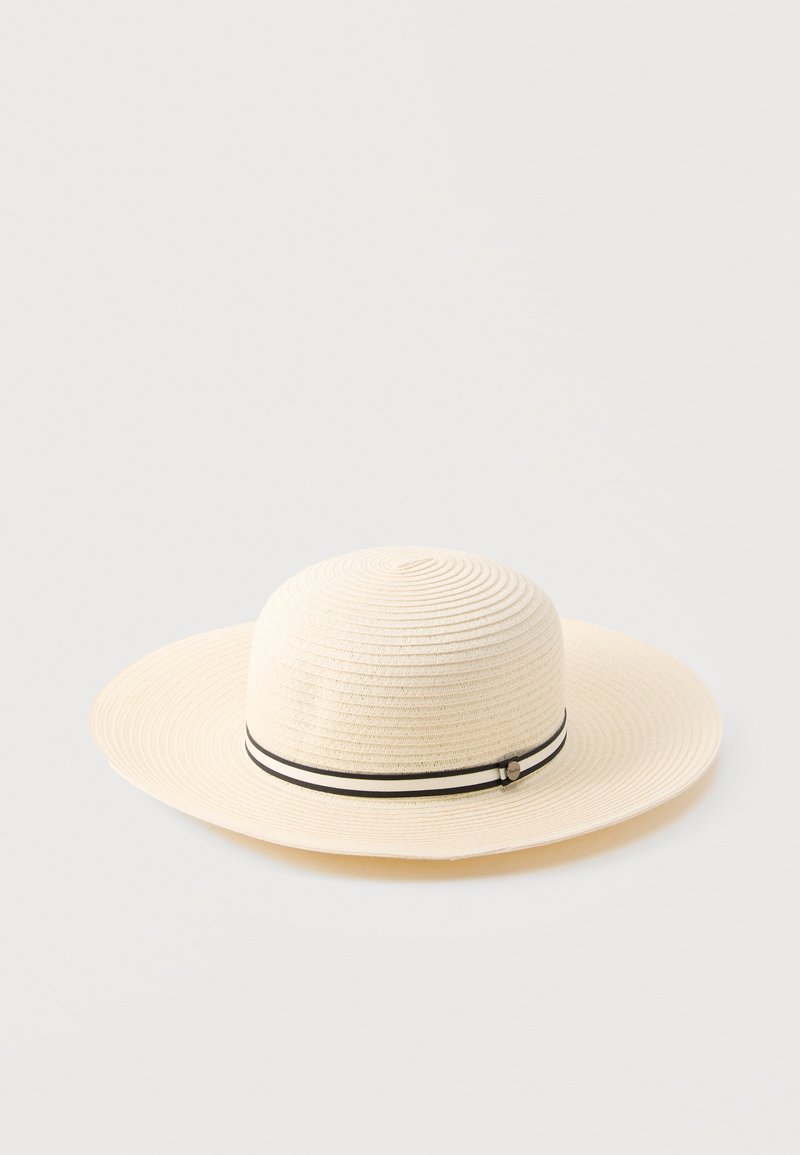 Καπέλο ηλίου με φαρδιά γείσο σε μπεζ απόχρωση, με κεντρική υφή ύφανσης σε ομόκεντρους κύκλους και λεπτή μαύρη και λευκή ριγωτή ταινία γύρω από τη βάση του στεφάνου.