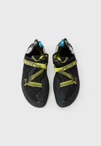 Un paio di scarpe da arrampicata nere e gialle con cinturini in Velcro etichettate "Veloce", posizionate affiancate su uno sfondo bianco.