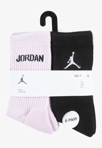 Seis pares de calcetines deportivos en rosa y negro. Textura de punto con las letras "JORDAN" y el logo en blanco. Empaquetados con una etiqueta colgante.