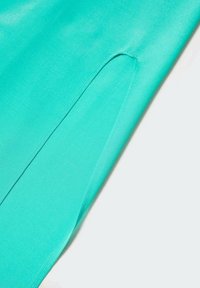 Turquoise fabric with a smooth, slightly shiny texture features a side slit, showcasing a clean, contemporary design.