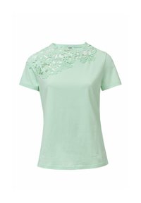 Camiseta verde menta clara hecha de una tela suave, con detalle de encaje floral en el hombro izquierdo y diseño clásico de cuello redondo.