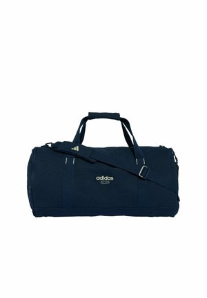 Borsa sportiva Adidas blu scuro con doppie maniglie, tracolla regolabile e logo frontale su sfondo bianco semplice.