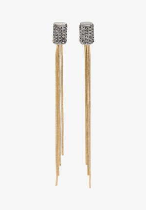 Srebrzyste cylindryczne kolczyki z czarnymi wzorami z ćwieków oraz długimi, cienkimi złotymi łańcuszkami zwisającymi jako kolczyki.