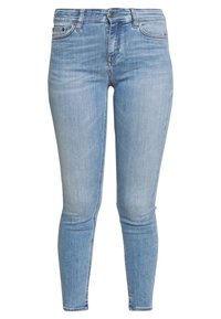 Jeans skinny de color azul claro hechos de denim. Cuentan con una cintura de altura media, cinco bolsillos y un leve desvanecimiento a lo largo de las piernas. Cierre clásico con botón.