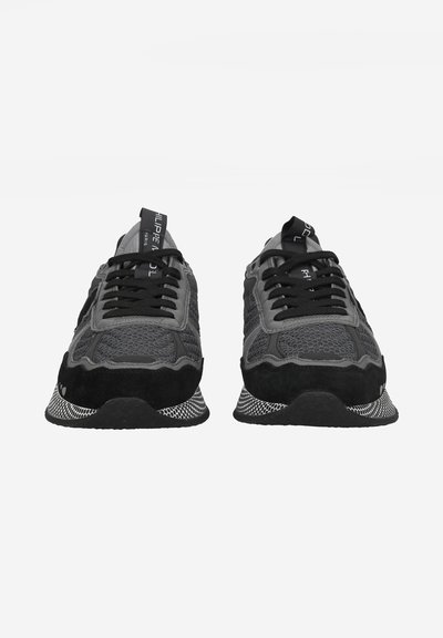 Sneakers neri con una parte superiore in mesh testurizzato, dettagli in suede e suola bianca a contrasto. Presentano lacci neri e un'etichetta sul linguetta con il marchio.