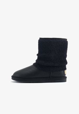 Crne čizme do gležnja s mekim, plišanim teksturom na vrhu i glatkom kožom na donjem dijelu. Gumeni potplat s logotipom.