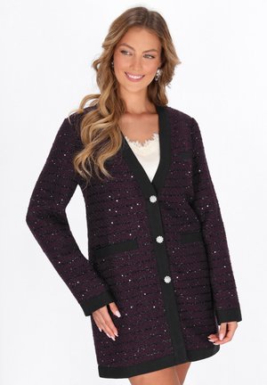 Cardigan viola testurizzato con accentuazioni nere, dotato di scollatura a V, due tasche frontali e bottoni decorativi.