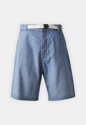 Lysblå denimshorts med en taljevende, der har et hvidt bælte og en sort spænde, med syninger og en løs pasform.