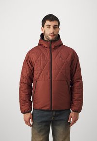 Maroon quilted jacket with a hood, featuring a front zipper and black accent hardware. It has a diamond pattern and long sleeves.