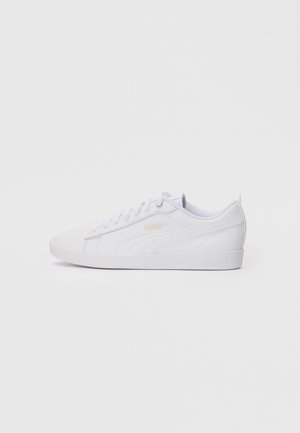 Baskets basses blanches Puma avec fermeture à lacets, logo discret sur le côté et le talon, et semelle en caoutchouc propre.