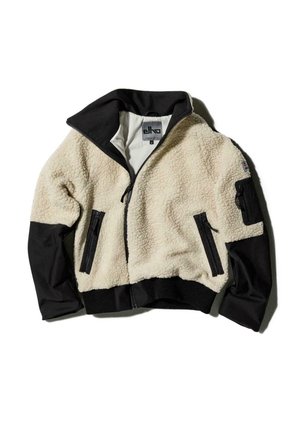 Veste en polaire avec un devant crème et des manches noires. Dotée d'un col haut, de poches zippées et de poignets élastiques à l'ourlet.