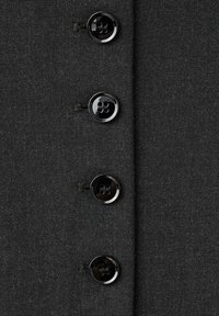 Tejido gris oscuro con una superficie texturada, que presenta cuatro botones de plástico negro con cuatro orificios cada uno, alineados verticalmente a lo largo del borde.
