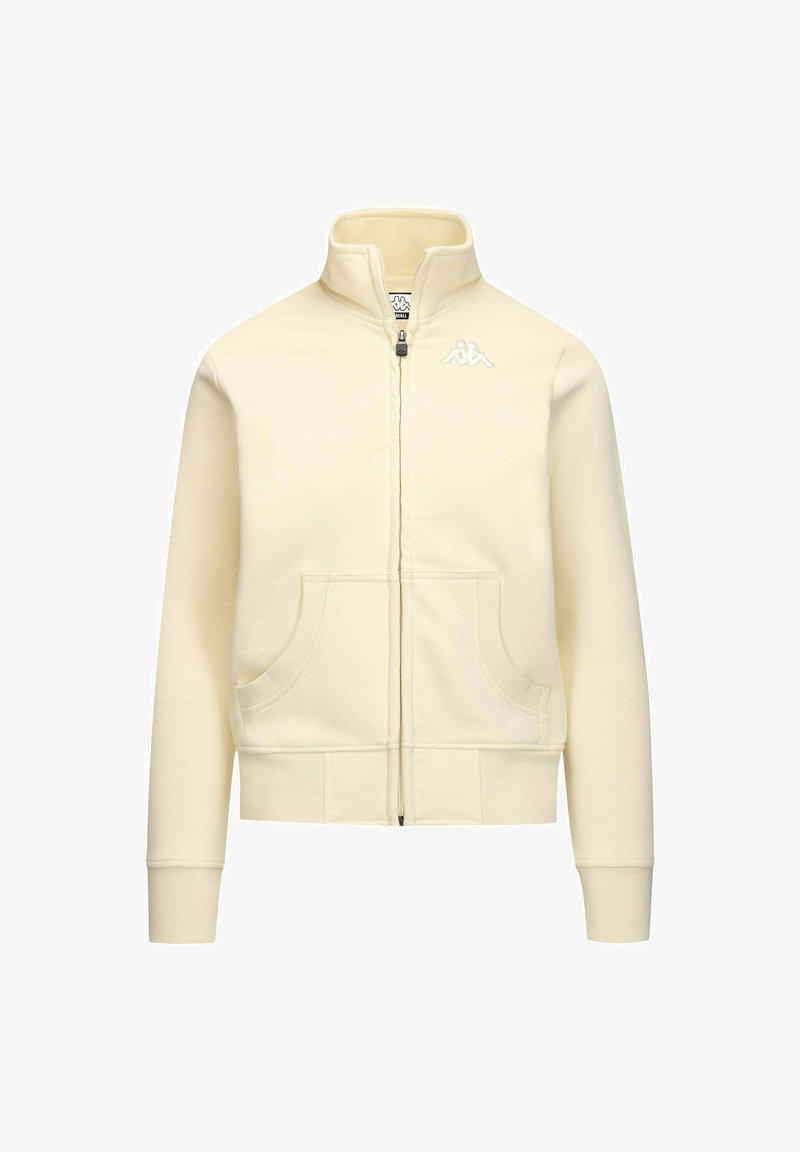 Felpa cremosa con zip e colletto alto, due tasche frontali, polsini e fondo a costine, e un piccolo logo bianco sul lato sinistro. Tessuto morbido.