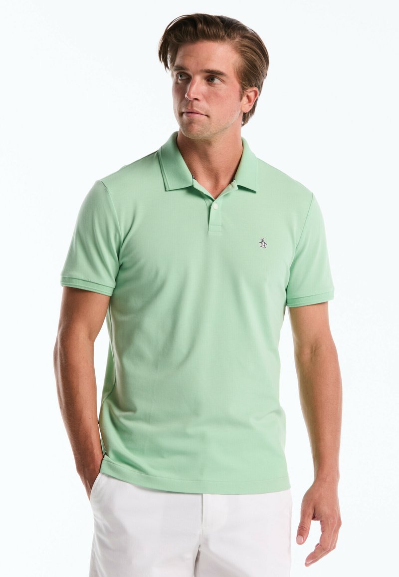 Mintgroene poloshirt van een zachte stof, met een kraag, drie knopen en een geborduurd logo op de linkerborst.