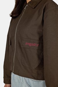 Pruun lukkidega jakk, millel on sametkaelus, kahe esipocketi ja punase tikandiga logo. Tekstuuriga kangas ja lühike disain.