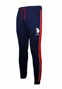 Navy sweatpants with red drawstring, featuring white logo and red side stripes with text "U.S. POLO ASSN." in repeating pattern. Soft fabric, tapered fit.