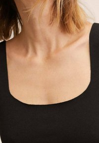 Vêtement noir avec un décolleté carré, présentant une texture lisse et une coupe ajustée. Peau visible autour du cou.