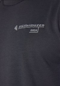 Black short-sleeve shirt made of textured fabric featuring a gray logo and brand name printed on the chest area.