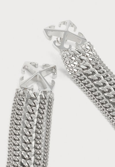 Bracelet chaîne en argent avec plusieurs brins liés et fermoirs métalliques en forme de flèche sur fond blanc.