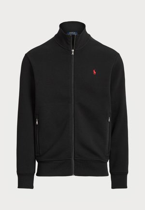Sort zip-up jakke lavet af en bomuldsblanding, med høj krave, to sidelommer med lynlås og et lille rødt logo på venstre bryst.