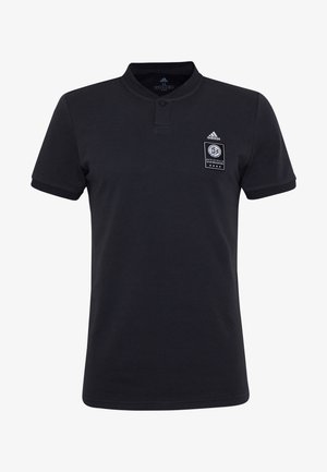 Polo noir en coton avec un col à boutons, manches courtes et un badge rectangulaire affichant un emblème blanc sur la poitrine gauche.