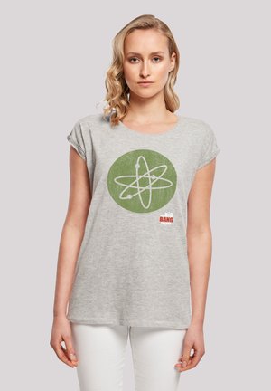 Graues T-Shirt mit kurzen Ärmeln, das ein grünes rundes Grafikdesign mit einem weißen Atom und dem roten Text "Big Bang Theory" zeigt.