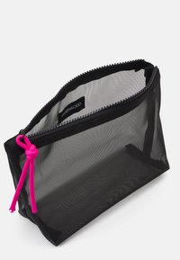 Pungă cosmetică din plasă neagră cu un fermoar roz și detaliu nod. Formă rectangulară, ușoară și transparentă pentru a oferi vizibilitate conținutului.