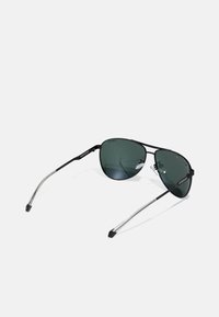 Ochelari de soare aviator negri cu lentile nuanțate în verde, accente argintii pe brațe și suporturi pentru nas din silicon transparent.
